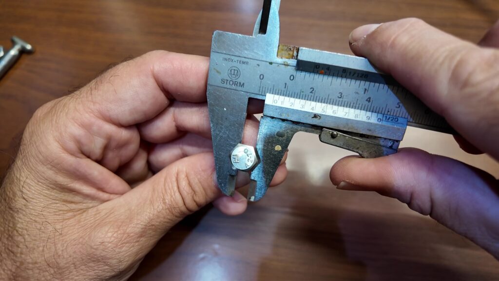 Pied à coulisse numérique mesurant le diamètre d'une vis métrique en acier inoxydable